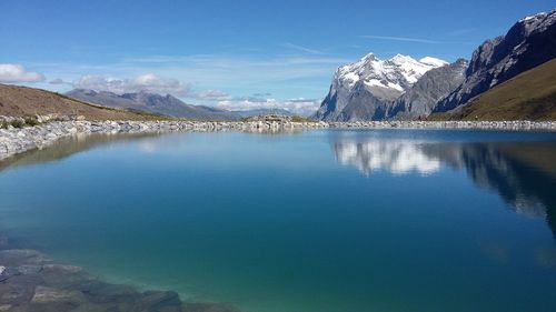 Scenic view of lake and mountains against blue sky