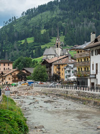 Houses by river against mountain