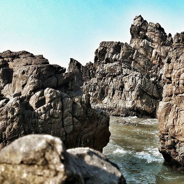 rock formation, rock - object, clear sky, scenics, tranquil scene, tranquility, beauty in nature, water, rock, nature, cliff, geology, sea, eroded, rocky mountains, rocky, blue, rough, physical geography, idyllic