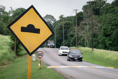 Bumpy road ahead sign, speed bump traffic sign, on road in green forest park, khao yai national park