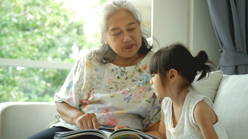 Mother and daughter sitting on floor