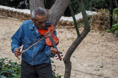 Man playing violin outdoors