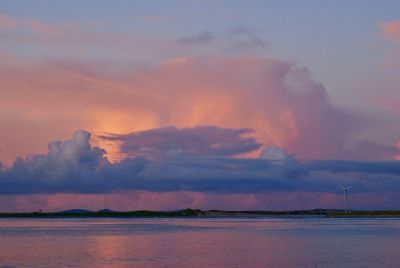 Scenic view of sea against dramatic sky during sunset