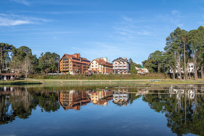 Houses by lake against sky