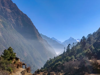 Panoramic view of mountains against clear blue sky