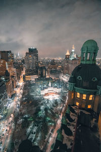 High angle view of illuminated cityscape against sky at night