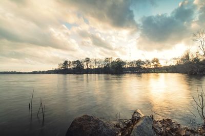 Scenic view of river against sky at sunset