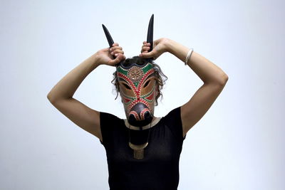 Portrait of woman wearing mask against white background