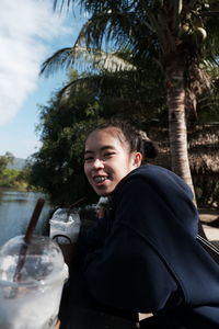 Portrait of smiling man drinking water from tree