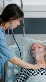 Side view of doctor examining patient at clinic