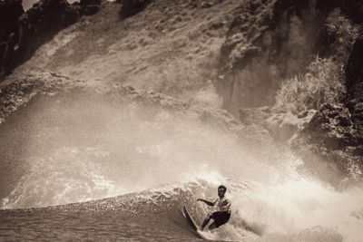 Rear view of man surfing in sea