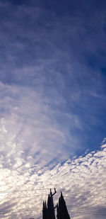 Low angle view of cross on building against sky