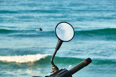 Close-up of coin-operated binoculars with sea in background