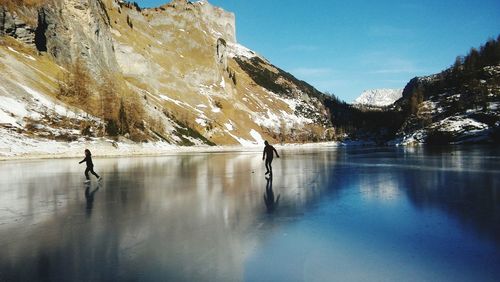 People ice-skating on frozen lake