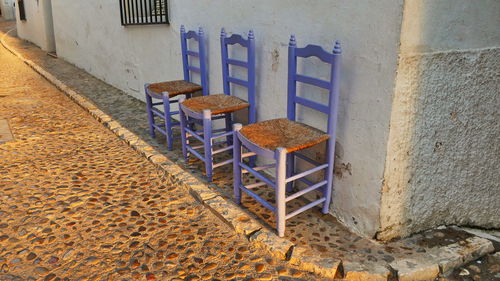 Empty chairs against wall in old building