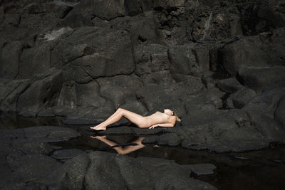 Woman lying on rock