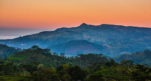 Scenic view of mountains against clear sky at sunset