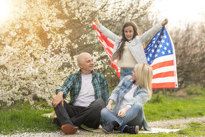 American family with usa flag outdoors.