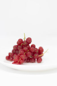 Close-up of cherries over white background