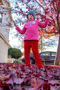 Low angle view of woman standing by pink tree