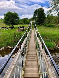 Wooden footbridge against sky