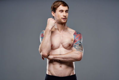 Portrait of shirtless man against black background