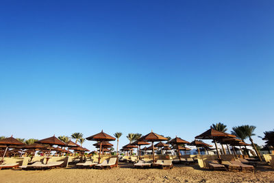 Houses on beach against clear blue sky