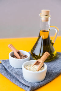 Sesame and flax seeds wooden spoons with oil in glass bottle. healthy food concept. vegan keto diet.