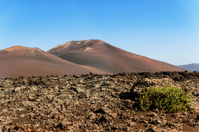 Scenic view of desert against clear blue sky