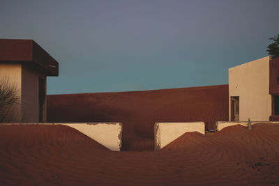 Buildings in desert against clear sky