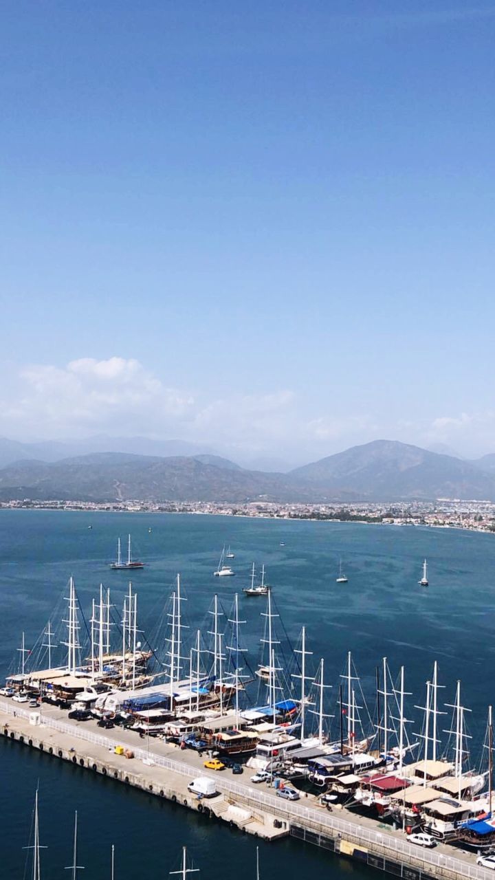 SAILBOATS MOORED AT HARBOR