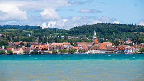 Buildings by sea against sky