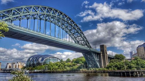 View of bridge over river against cloudy sky