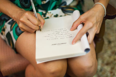 Close-up of woman writing notes