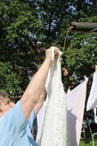 Side view of woman arranging wedding dress on clothesline