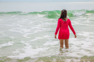 Rear view of woman standing on beach