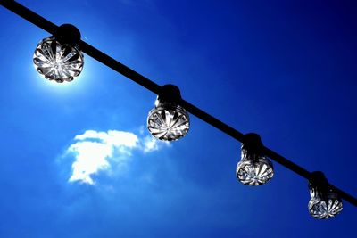 Low angle view of illuminated street light against blue sky