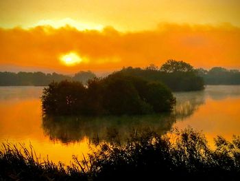 Scenic view of lake against orange sky