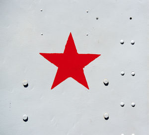 Close-up of red star on metallic wall