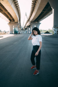 Full length of woman standing on bridge in city