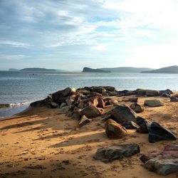 Scenic view of beach against cloudy sky