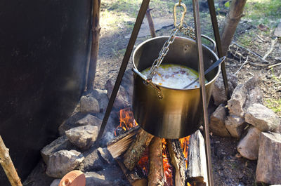 High angle view of food preparing in casserole over campfire