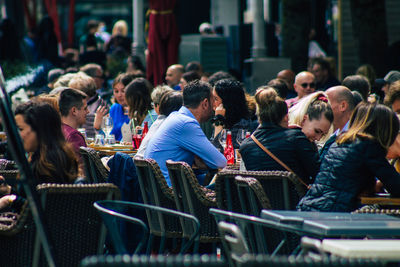 Group of people sitting on seat in city