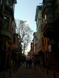 People walking on footpath amidst buildings in city
