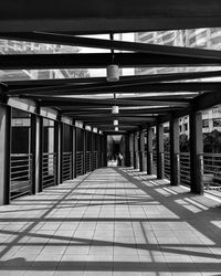 Empty covered walkway in city during sunny day