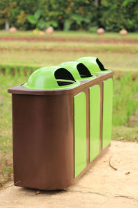 Close-up of garbage bin on field