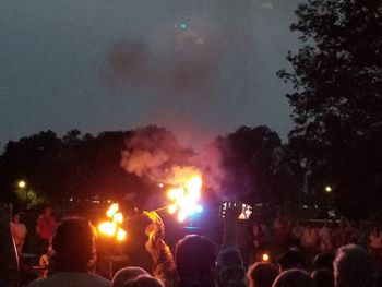 Crowd at music concert against sky at night