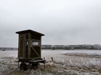 Lifeguard hut on agricultural field against sky