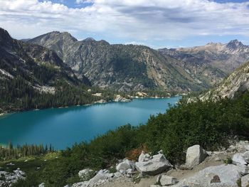 Scenic view of lake by mountains against sky