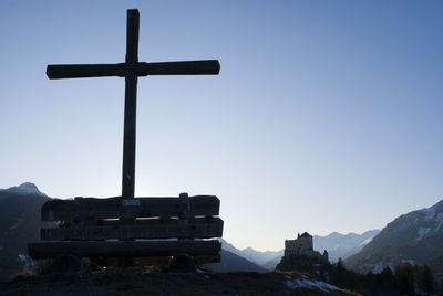 Cross on mountain against clear sky